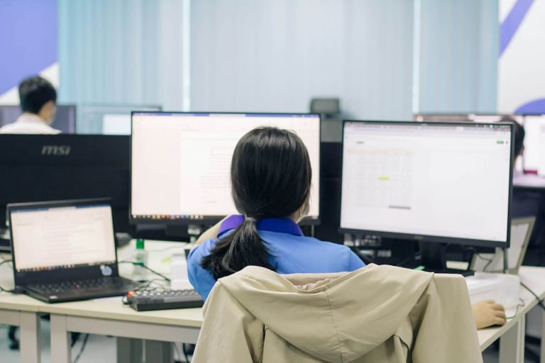 パソコンに向かい、業務効率化に成功した笑顔の会社員のイラスト
